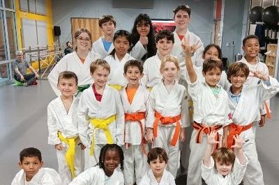 Posed youth class photo of 18 boys and girls including new belt recipients.